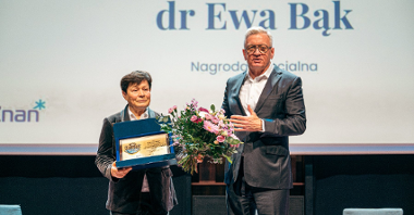 Na zdjęćiu mężczyzna wręczający kwiaty kobiecie- prezydent Poznania i dyrektorka wydziału sportu